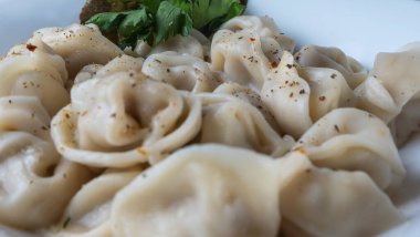 Kaynamış etli börek. Rus kaynamış pelmeni 'nin beyaz tabakta yakın plan görüntüsü. Haşlanmış ev yapımı Rus köftesi ya da etli pelmeni..