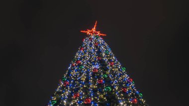 Noel ağacının ışıkları Bokeh 'i karanlık arka planda fotokopi aletiyle bulanıklaştırdı. Soyut şenlik arka planı. Metin için boşluk.