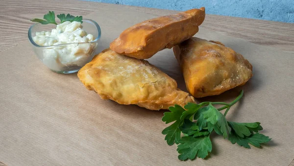 Lezzetli kızarmış chebureki soslu ve parşömenli maydanozlu. Fast food konseptleri. Aperatif. Sokak yemekleri..