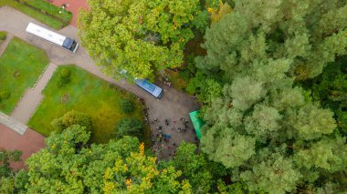 Otoparktaki otobüslerin ve turistlerin hava manzarası. Turist modern otobüsleri güneşli bir günde turistleri bekliyor..