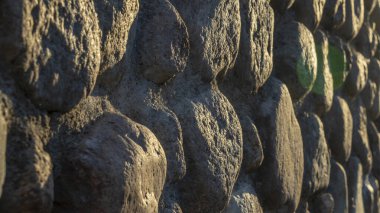 Gri ezilmiş taşlar ve güneş ışığıyla gerçek bir arka plan. Yaz günlerinde eski tuğla duvar. Soyut dekoratif arkaplan veya sanat dokusu.