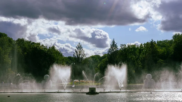 Çeşmeden su. Bulutlu gökyüzünün arkasındaki çeşme akıntısının tepesinde. Nehirdeki çeşme dramatik gökyüzüne karşı.