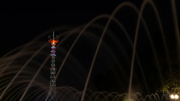 电视塔在节日照明 在具有长曝光水滴的前景喷泉上 明斯克日庆祝活动在河里点燃了灿烂的焰火 — 图库照片