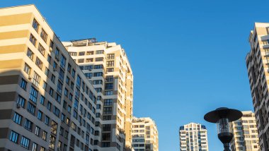Yüksek binaların yakınındaki sıkışık avlu. Mavi gökyüzünün arka planında büyük bir apartman. Komşuluk kavramları.