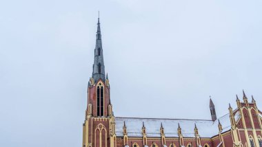 Kışın Gervyaty, Belarus 'taki Gervyaty kasabasındaki Neo-Gotik katedral kilisesi dramatik gökyüzü arka planında. Mesaj için yer var. Din ve tarihi miras kavramları.