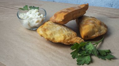 Lezzetli kızarmış chebureki soslu ve parşömenli maydanozlu. Fast food konseptleri. Aperatif. Sokak yemekleri..