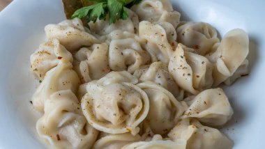 Kaynamış etli börek. Rus kaynamış pelmeni 'nin beyaz tabakta yakın plan görüntüsü. Haşlanmış ev yapımı Rus köftesi ya da etli pelmeni..