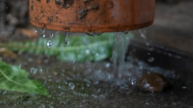 Şiddetli yağmur. Yağmur suyu çatıdan drenaj borusuna akıyor..