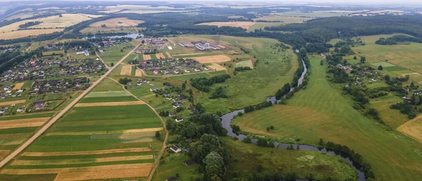 Yeşil tarladaki kıvrımlı nehrin havadan manzarası, insansız hava aracının güzel doğa arka planının üst görüntüsü. Kopya alanı olan mevsimlik yaz manzarası.