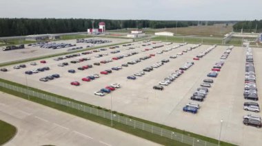 Hava manzaralı yeni araba ithalat ve ihracat işi lojistiği için otomobil fabrikasının sokak parkında satılığa çıktı. Ticari iş dünyası için otomobil ve otomobil otoparkı.