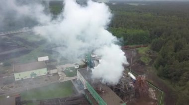 Turba fabrikasının endüstriyel bacasından sıcak buhar geliyor. Köydeki turba tütün fabrikası. Bacadan duman çıkıyor..