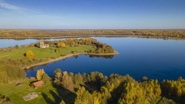 Sonbahar ormanı ve göl manzarası. Orman gölü üzerinde sonbahar güneşli bir akşam. Kırsal alan.