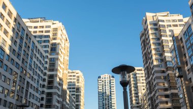 Yüksek binaların yakınındaki sıkışık avlu. Mavi gökyüzünün arka planında büyük bir apartman. Komşuluk kavramları.