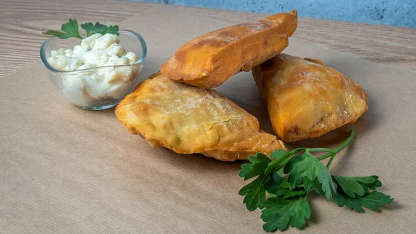 Lezzetli kızarmış chebureki soslu ve parşömenli maydanozlu. Fast food konseptleri. Aperatif. Sokak yemekleri..