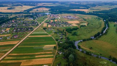 Yeşil tarladaki kıvrımlı nehrin havadan manzarası, insansız hava aracının güzel doğa arka planının üst görüntüsü. Kopya alanı olan mevsimlik yaz manzarası.