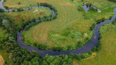 Aerial landscape of winding river in green field, top view of beautiful nature background from drone. Space for text.