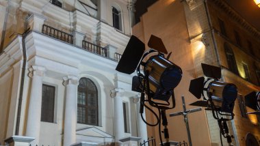 Koyu arkaplanda profesyonel video aydınlatma ekipmanı. Geceleri sokaklarda ligthing tekniği. Parlak ışıklandırma ekipmanı.