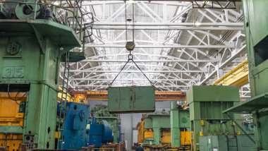 Ulaşım, üretim ve üretim için vinç veya köprü vinç kaldırma işlemini içerir. Vinç üzerindeki fabrika deposu yükü kaldırıyor.,