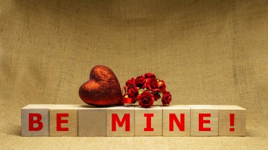 Wooden cubes with phrase BE MINE on sackloth background. Business concept