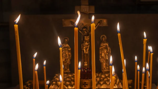 Kilise mum ışığı. Mum cilası. Ortodoks kilisesinde ya da tapınağında yanan mumlar var. Seçici odaklanma. Tapma kavramları.