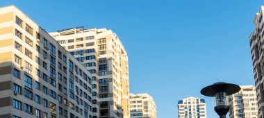 Yüksek binaların yakınındaki sıkışık avlu. Mavi gökyüzünün arka planında büyük bir apartman. Komşuluk kavramları.