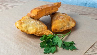 Lezzetli kızarmış chebureki soslu ve parşömenli maydanozlu. Fast food konseptleri. Aperatif. Sokak yemekleri..