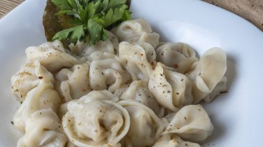 Kaynamış etli börek. Rus kaynamış pelmeni 'nin beyaz tabakta yakın plan görüntüsü. Haşlanmış ev yapımı Rus köftesi ya da etli pelmeni..