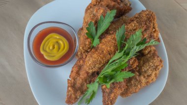 Beyaz tabakta soslu haşlanmış tavuk şeritleri. Kızarmış tavuk kızartması. Fast food beyaz tabak arka planda. Fast food kavramları.