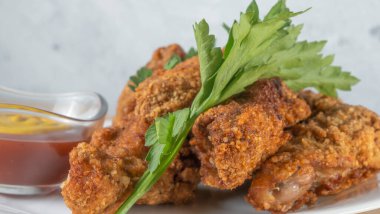 Beyaz tabakta soslu haşlanmış tavuk şeritleri. Kızarmış tavuk kızartması. Fast food beyaz tabak arka planda. Fast food kavramları.