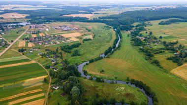 Yeşil tarladaki kıvrımlı nehrin havadan manzarası, insansız hava aracının güzel doğa arka planının üst görüntüsü. Kopya alanı olan mevsimlik yaz manzarası.