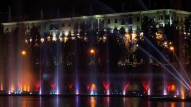 Geceleyin bir nehirde çok renkli bir müzik çeşmesi. Aydınlanmadan kaynaklanan gece çeşmesi. Mesaj için yer var. Kutlama konsepti.