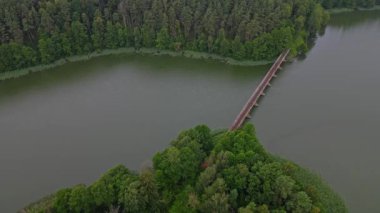 Nehrin üzerinde eski bir köprünün üzerinden uçmak, yağmurda dar demiryolu ve orman ölçümleri. Doğa konsepti.