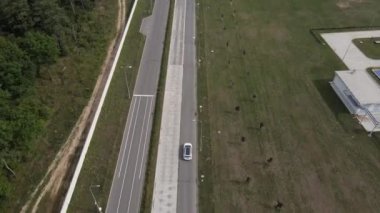 Test pistinde tur atan yeni bir elektrikli arabanın havadan görüntüsü. Elektrikli araba test sürüşü. Yeşil enerji kavramı.