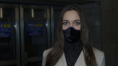 Yeraltı istasyonunun yakınında tıbbi maskeli bir kadın. Koronavirüse karşı koruyucu maske takan bir kadın. Dışarıdaki güvenlik için yüz temizleme maskesi..
