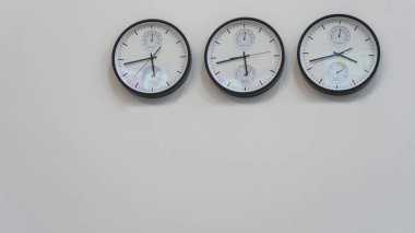 Dünyanın farklı başkentlerinde zamanı gösteren üç duvar saati. Metin için boşluk.