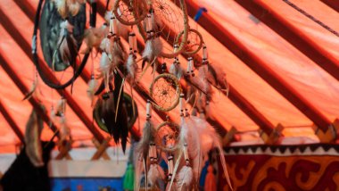 Tüyleri iplik ve boncukları sallanan el yapımı rüya yakalayıcının yakın çekim görüntüsü.