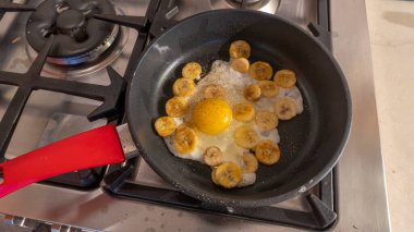 Çırpılmış yumurtalı kızarmış muz pişirme işlemi. Sıcak tavada yumurtalı kızarmış muz. Tatlı bir yemek için egzotik bir tarif..