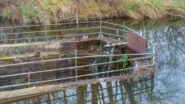 Baraj gölünde büyük bir çukur. Göl kıyısındaki çukurun manzarası. Barajın dibinden drenaj suyu çekiliyor..