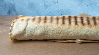 Shawarma tavuk sarması. Izgara et, peynir, lahana, havuç, sos ve yeşille doldurulmuş taze lavaş veya pita ekmeği. Geleneksel Doğu atıştırması.