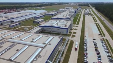 Gündüzleri endüstriyel kompleksin modern dış yüzeyi. Makineler için park yeri olan imalat yapısının hava görüntüsü.
