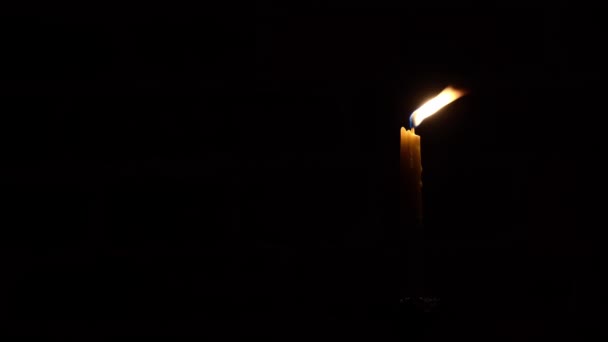 暗い背景にキャンドルの炎のクローズアップ 溶かしたワックスキャンドルライトボーダーデザイン スローモーションビデオ 夜に燃えるキャンドルライト ワイドスクリーン — ストック動画