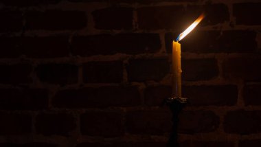 Karanlık bir arka planda mum alevi yakın plan. Eritilmiş mum ışığı sınır tasarımı. Uzun pozlama. Karanlık. Gece yanıyor, mum ışığı. Geniş Ekran