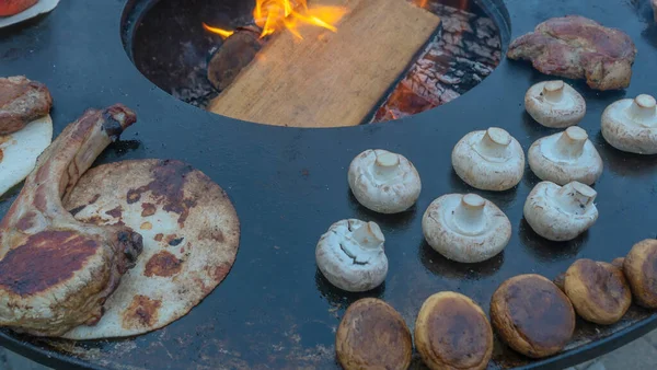 トマホークステーキは炭火グリルで焼き上げられます 骨にステーキを焼きます フラットレイアウト ストリートフードの概念 厚いトマホーク リビー チョップステーキとシャンパンを屋外グリルで焼く — ストック写真
