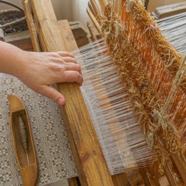 El yapımı kumaş dokuma ve üretimi. Dokuma tezgahının arkasında kadın eli bez yapar. Geleneksel kavram.