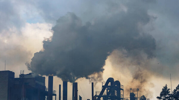 Industry and ecology problem. Dark smoke of the peat plant polluties the environment. Industry background.