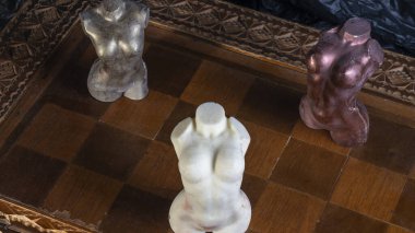 Satranç tahtasındaki çıplak kadın vücudu şeklinde çikolata figürler. Transseksüel tolerans. LGBT sorunları. Cinsiyet eşitliği.