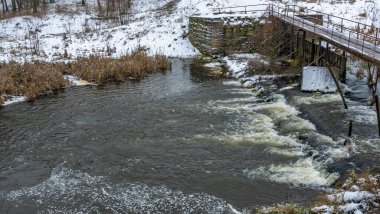 Küçük bir nehrin üzerinde eski bir köprü. Kırsal bölgedeki ilk kar. Metin için boşluk.