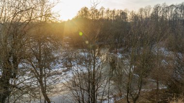 Kış manzarası. Güneş, tarla ve ağaçlarla kaplı. Kar tarlasında büyülü kış günbatımı. Doğa kavramları.