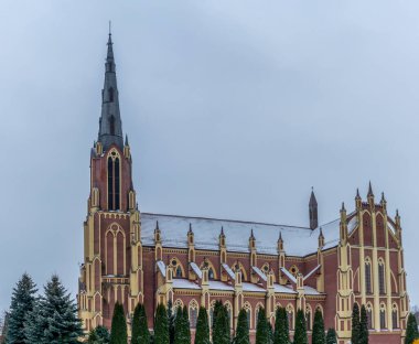 Kışın Gervyaty, Belarus 'taki Gervyaty kasabasındaki Neo-Gotik katedral kilisesi dramatik gökyüzü arka planında. Mesaj için yer var. Din ve tarihi miras kavramları.
