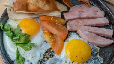 Jambonlu, domatesli ve maydanozlu omlet. Jambonlu, domatesli ve maydanozlu omlet. Yağda çırpılmış zengin bir kahvaltı..